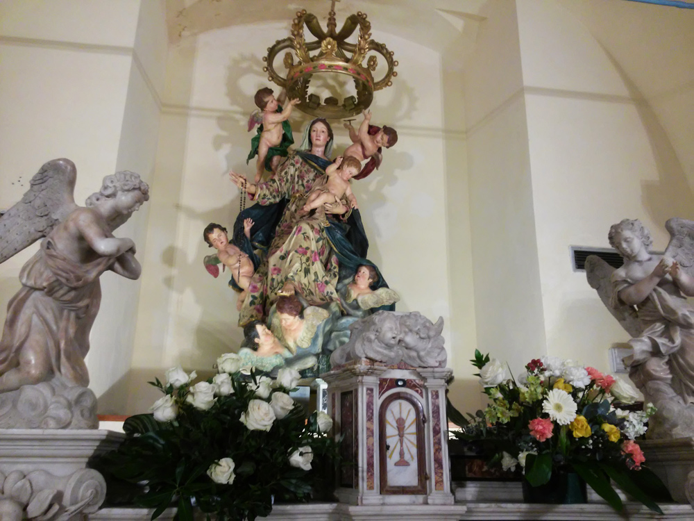 La Madonna del Rosario dietro gli angeli dell'altare