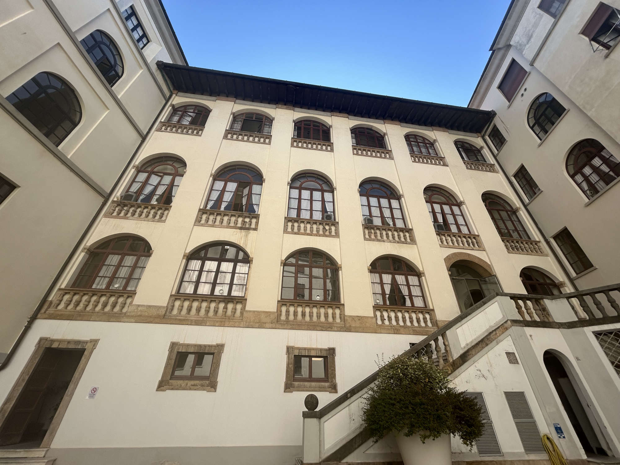 La fachada trasera vista desde el patio, y obtenida cerrando la logia. Foto: Jacopo Suggi