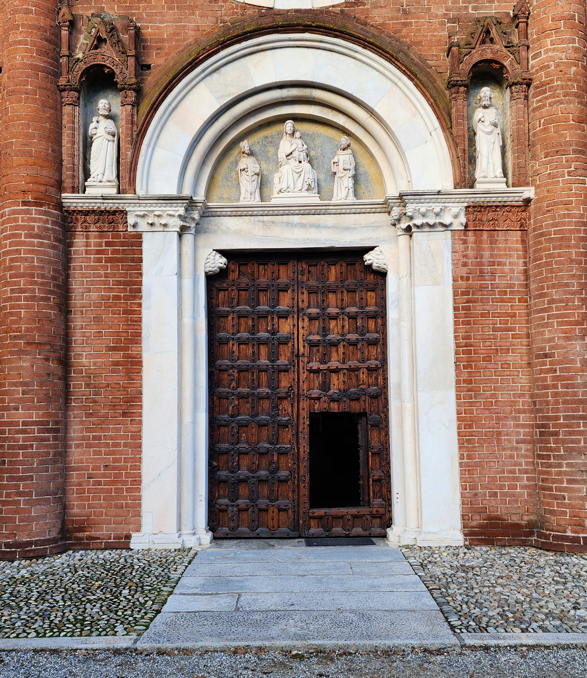 Le portail avec la porte d'origine et, dans la lunette, les œuvres du Maître des sculptures de Viboldone.