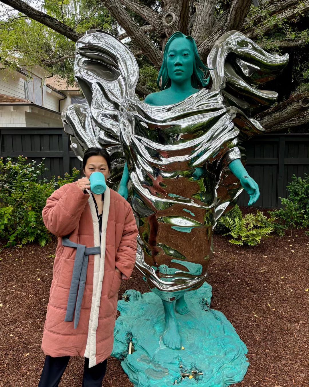 Priscilla Chan poses in front of the statue that her husband Mark Zuckerberg gave her